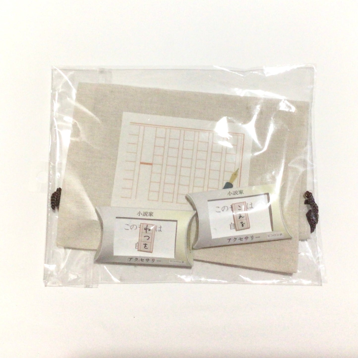 原稿用紙の巾着袋とピンバッジのセット