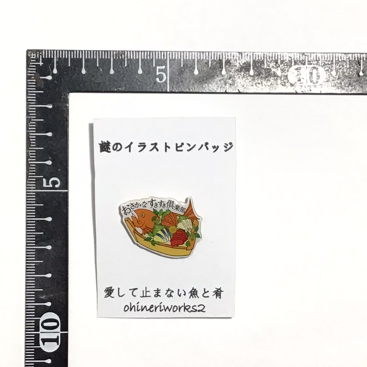 「愛して止まない魚と肴」　謎のイラストピンバッジ