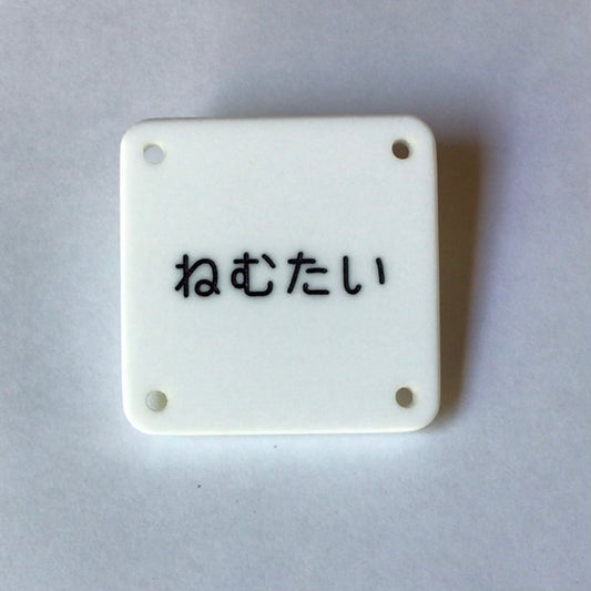 機械彫刻文字バッジ　「ねむたい」