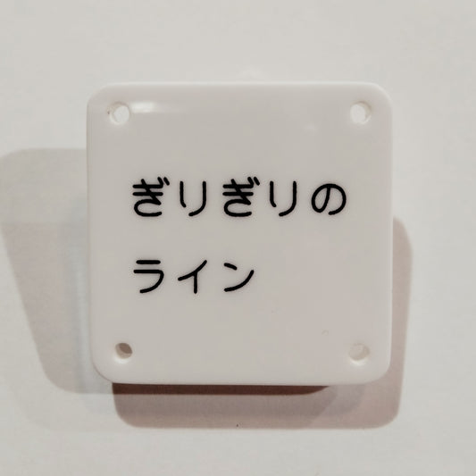 機械彫刻文字バッジ　「ぎりぎりのライン」